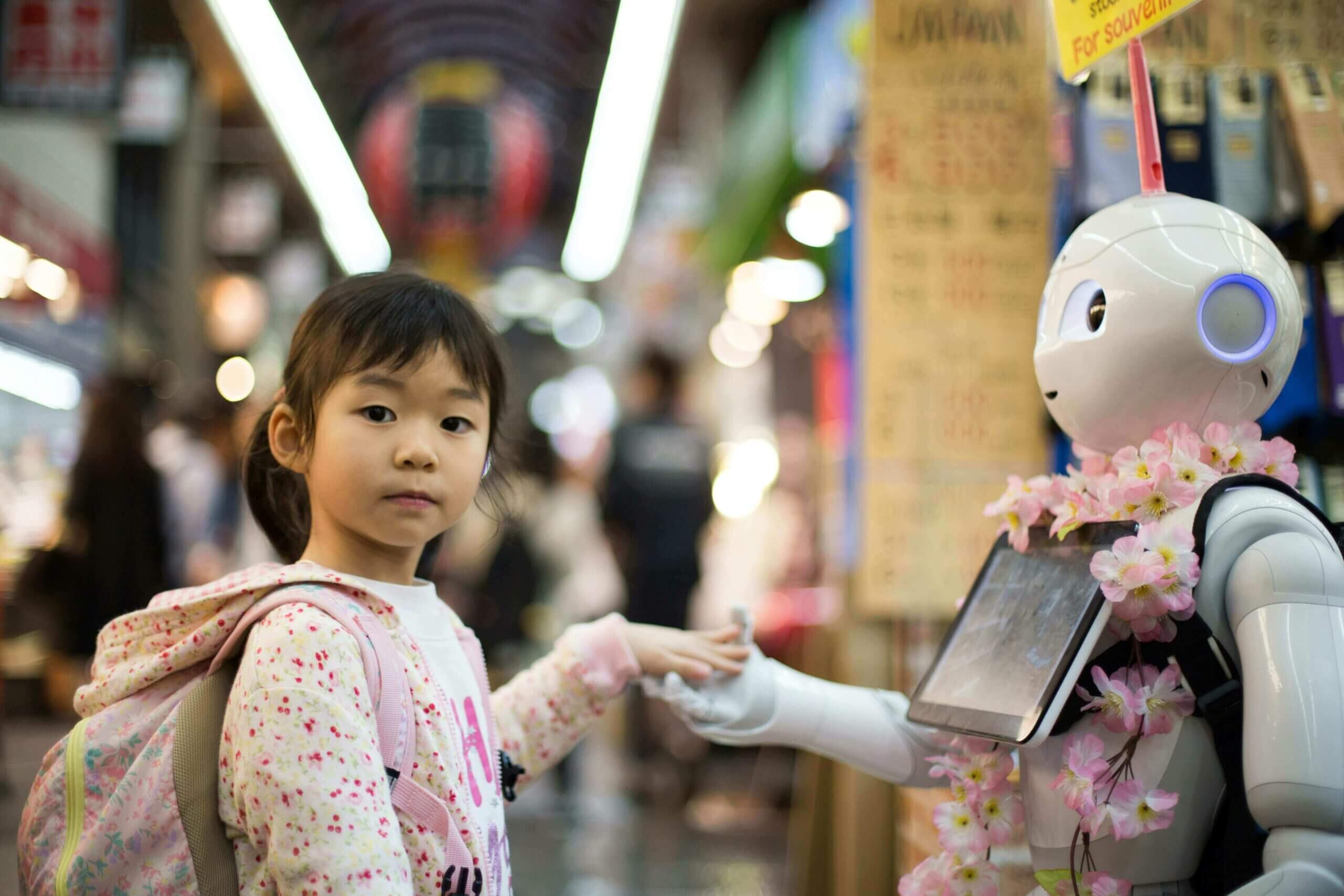 Roboter hält die Hand von einem Mädchen. Roboter/Leasing.